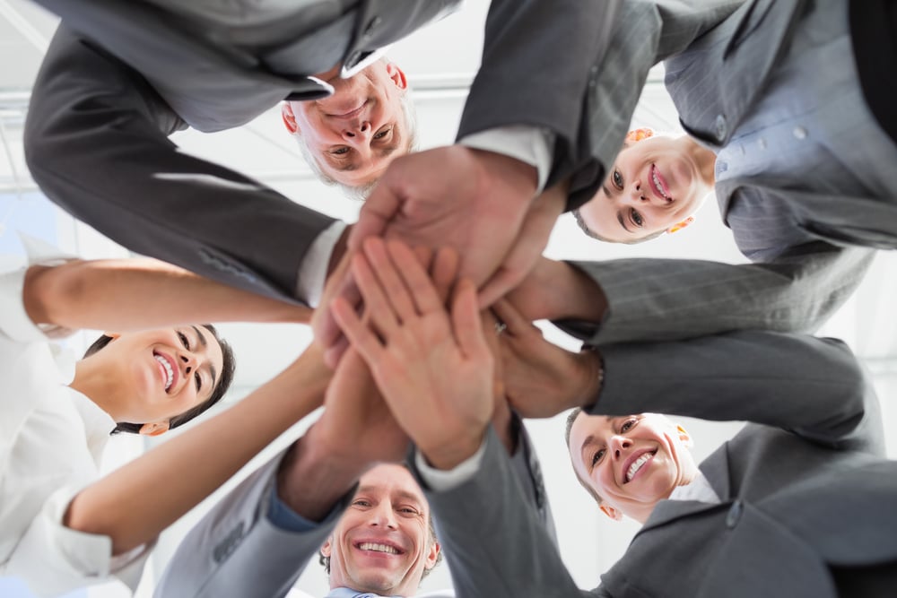 Business team standing hands together in the office