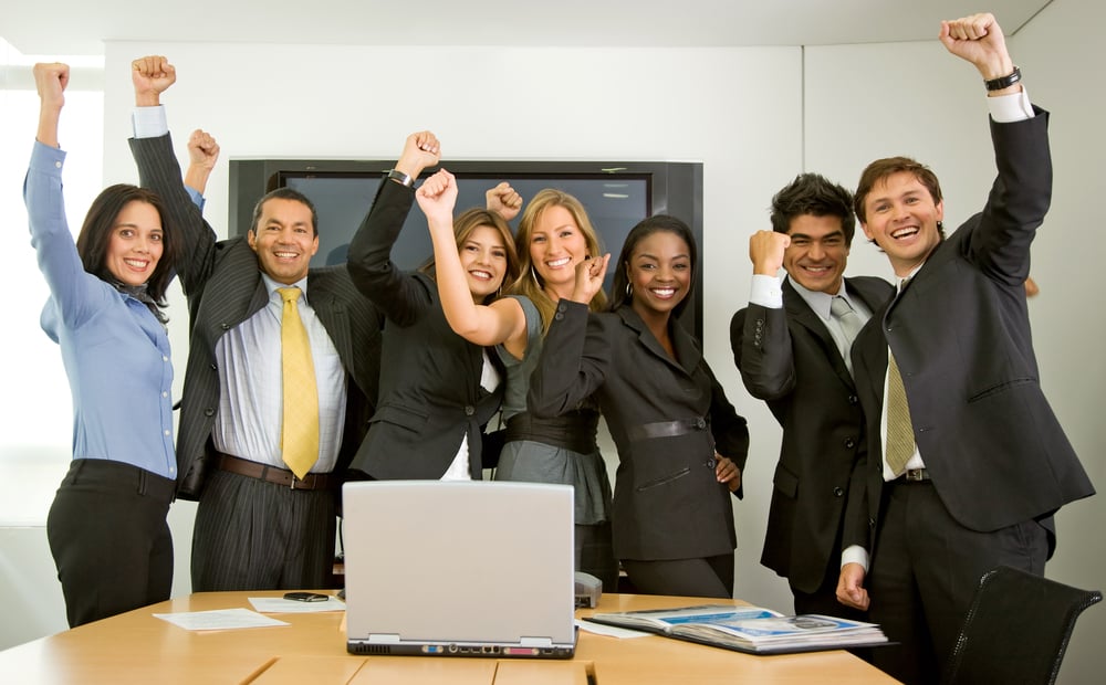 business team in an office full of success looking happy